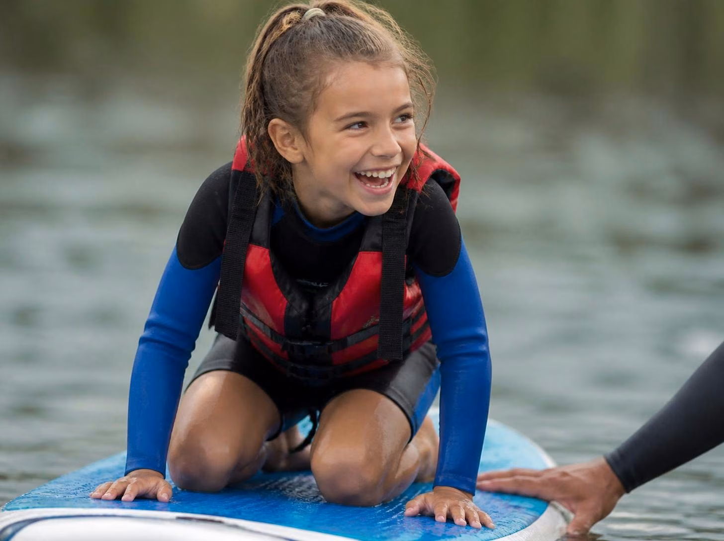 Illustrative image: girl on SUP, calm lagoon, instructor nearby